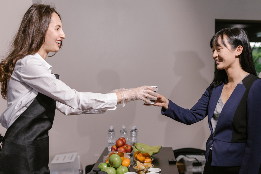 woman hands other woman cup